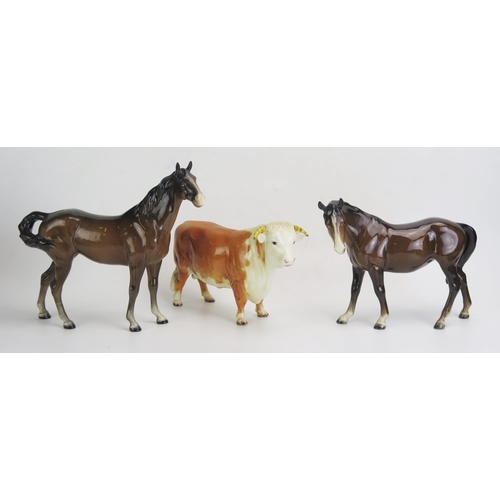 1657 - Two Beswick pottery stallions (one leg damaged) together with a model of a bull. (3).