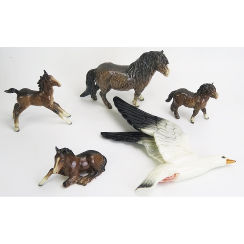 1658 - A Beswick pottery moorland pony and foal,  with two other foals and a seagull wall appliqué.