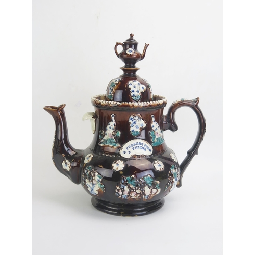 1662 - A large barge-ware teapot, with brown treacle glaze with applied flowerhead and bird decoration, the... 