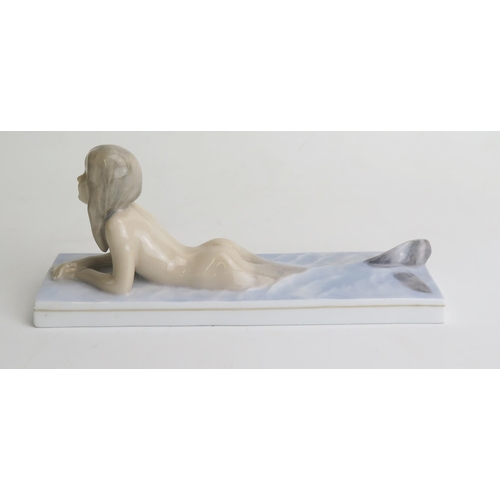 1666 - A Royal Copenhagen porcelain model of a mermaid, on a rectangular base, 19.5cm long.