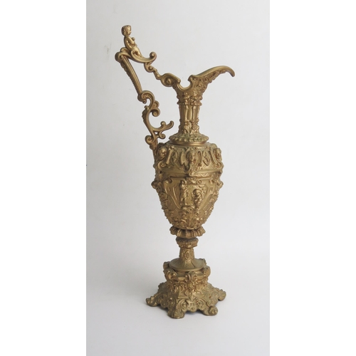 1683 - A gilt metal wine ewer garniture in the Italianate style , with scrolling handle, decorated with put... 