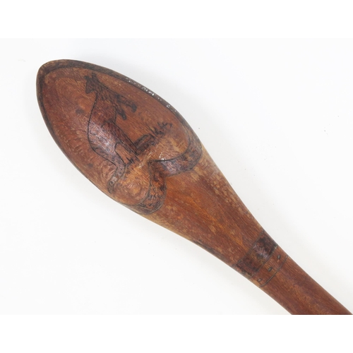 1825 - An Aboriginal club, the oval head decorated with a kangaroo and an emu, on slender shaft 60cm long.