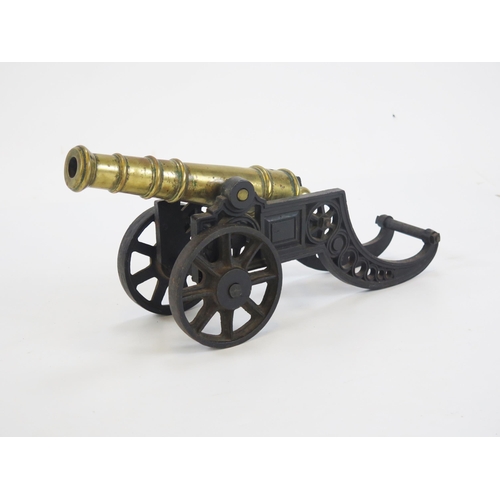 1826 - A cast iron model of a cannon, with 29cm brass barrel, with spoked wheels and pierced carriage, 45cm... 