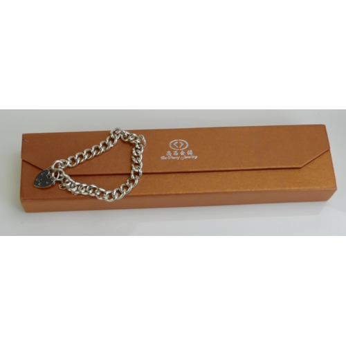 217 - A Silver Curb Link Bracelet with 'padlock' clasp, 31.17g. Boxed