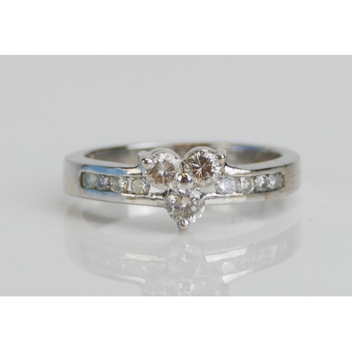 43 - A Platinum Three Stone Diamond Ring with diamond set shoulders, size K.5, 3.7gms