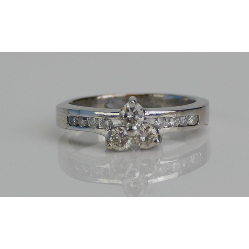 43 - A Platinum Three Stone Diamond Ring with diamond set shoulders, size K.5, 3.7gms