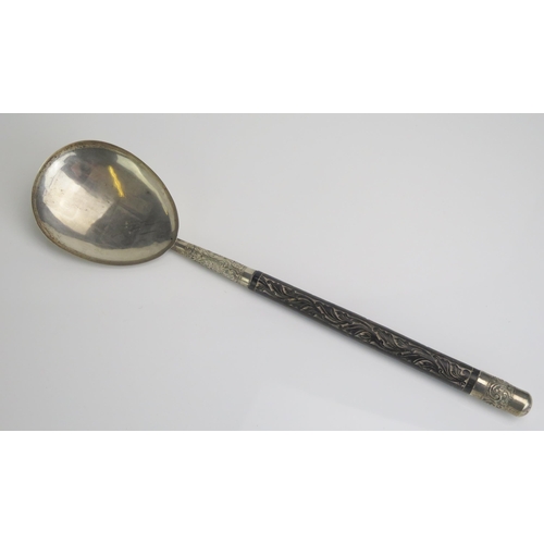 558 - An Indian silver serving spoon, with pear-shaped bowl on a carved wood handle and silver pommel, 36c... 