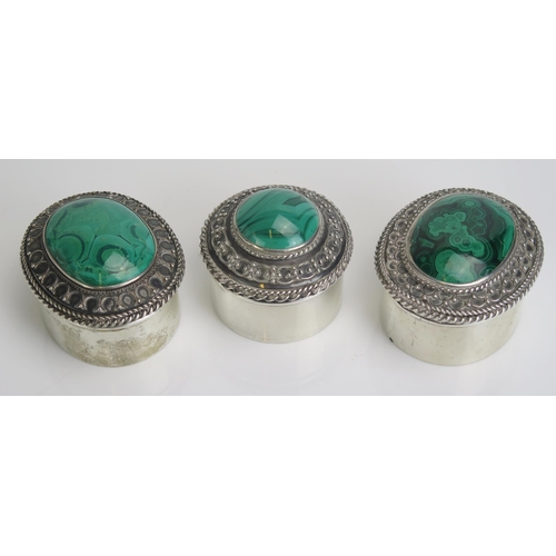 574 - Three sterling silver and malachite mounted dressing table boxes, two of oval outline the other bein... 