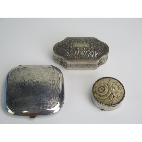 601 - A white metal box of cartouche-shaped outline, 9cm long, a silver plated and lava mounted circular b... 