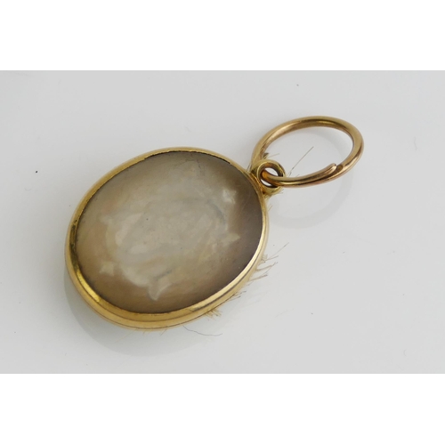 62 - A Victorian Memorial Locket in a precious yellow metal setting, decorated with a monogram and with a... 