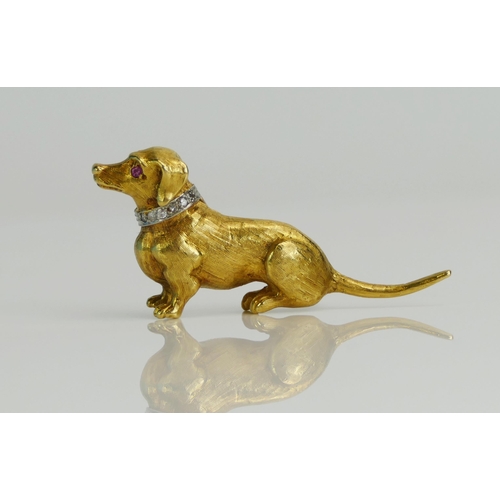 78 - An 18ct Gold Dachshund Brooch with a ruby eye and diamond set collar in a white metal setting, 43mm ... 