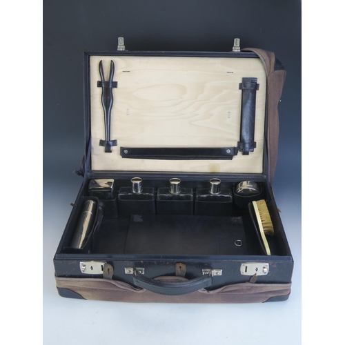 1755 - A gents stitched black leather vanity case, containing clear glass and plate mounted bottles, ivorin... 