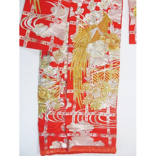 1767 - A 20th century Japanese red silk kimono, decorated with exotic bird amongst flowers, worked in gold ... 