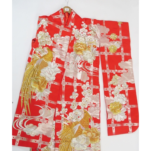 1767 - A 20th century Japanese red silk kimono, decorated with exotic bird amongst flowers, worked in gold ... 