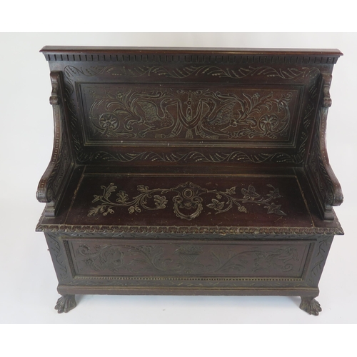 813 - A Carved Oak Settle with hinged lift up seat , the back carved with birds and the whole with foliate... 