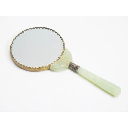 1046 - A Chinese porcelain backed hand mirror, with jadeite handle. 22cm long.