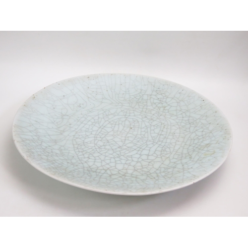 1058 - A large Chinese celadon charger, with crackle glaze decoration, 50cm diameter.