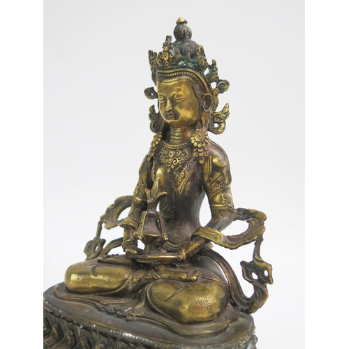 1074 - A Sino-Tibetan bronze statue of Buddha seated cross-legged on a lotus flower, 21cm high.