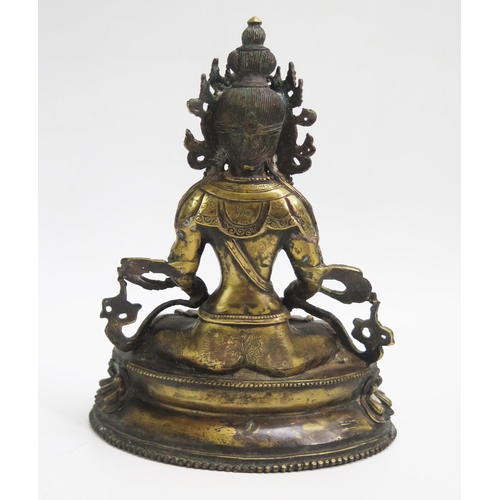 1074 - A Sino-Tibetan bronze statue of Buddha seated cross-legged on a lotus flower, 21cm high.