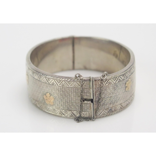 112 - A Victorian Style Silver Hinged Bangle with gilt flower head decoration, hallmarked, 31.07g