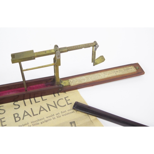 1219 - A 19th century folding brass sovereign scales, contained in a mahogany case, together with a Bakelit... 