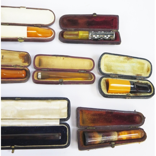 1227 - A collection of amber and other cheroot and cigarette holders, all cased.