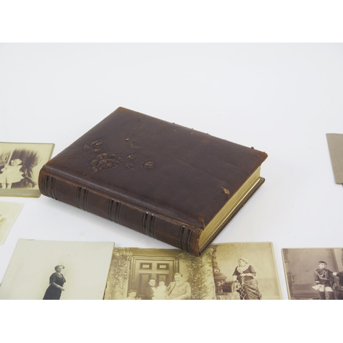 1237 - A Victorian photograph album containing various photographs and carte-de-visites, together with loos... 