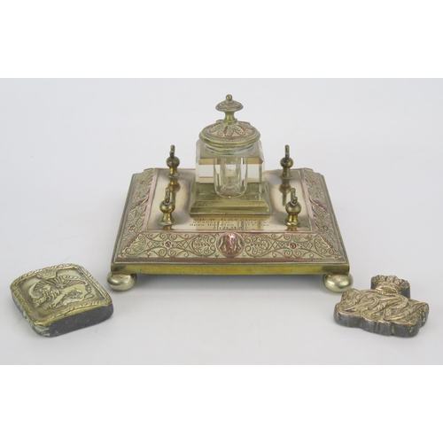 1353 - A late Victorian brass and copper ink stand, the square base with central glass inkwell, inscribed, ... 