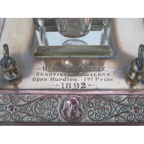 1353 - A late Victorian brass and copper ink stand, the square base with central glass inkwell, inscribed, ... 