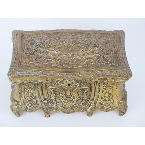 1361 - A cast brass rectangular jewellery casket, in the Italianate style, the hinged lid enclosing a velve... 