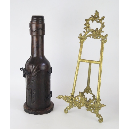 1362 - A cast brass easel stand, with foliate crest, 51cm high together with a wood bottle holder, (2)