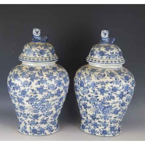 1408 - A pair of Chinese blue and white crackle glaze vase and covers of oval form, the covers surmounted b... 