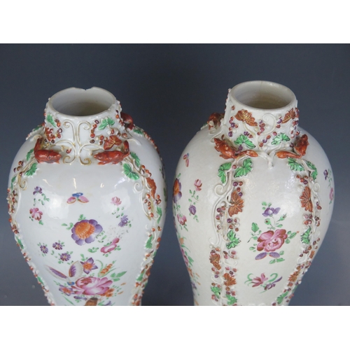 1415 - A pair of 19th century Chinese famille rose vases with raised floral decoration, a/f, 26cm high.