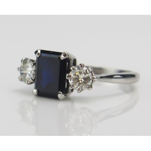 199 - An 18ct White Gold, Sapphire and Diamond Three Stone Ring, c. 8.5x6.6mm emerald cut and 4.57mm round... 