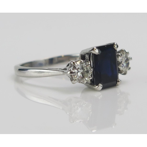 199 - An 18ct White Gold, Sapphire and Diamond Three Stone Ring, c. 8.5x6.6mm emerald cut and 4.57mm round... 