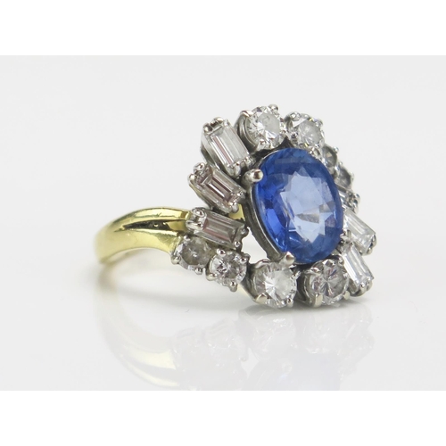 219 - An 18ct Gold, Sapphire and Diamond Cluster Ring, c. 9.1x7.4mm pale blue principal stone, surrounded ... 