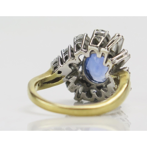 219 - An 18ct Gold, Sapphire and Diamond Cluster Ring, c. 9.1x7.4mm pale blue principal stone, surrounded ... 