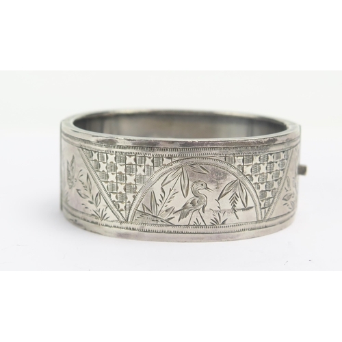 267 - A Victorian Silver Hinged Bangle with chased foliate and bird decoration, Birmingham 1876, 31.7g