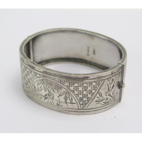 267 - A Victorian Silver Hinged Bangle with chased foliate and bird decoration, Birmingham 1876, 31.7g