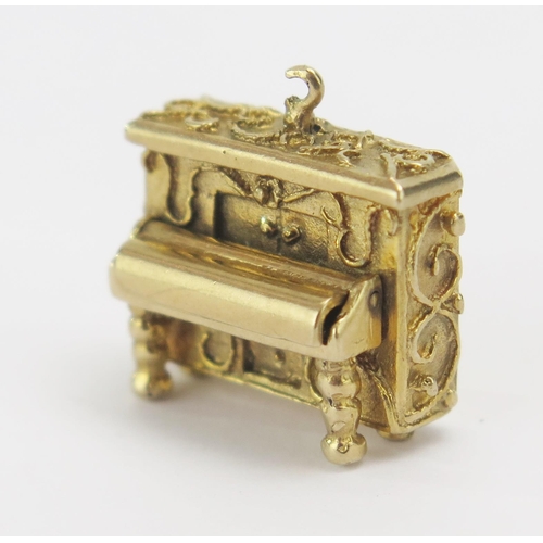 31 - A 9ct Gold Pianola Charm with hinged keyboard cover, hallmarked, 7.96g. Suspension loop damaged