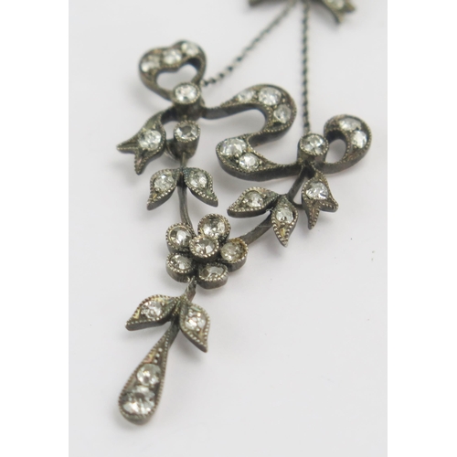 69 - An Antique Old Cut Diamond Pendant in a precious white metal mount, of foliate form beneath a bow su... 