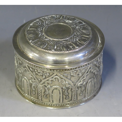 704 - A Persian circular silver box and cover, stamped marks, with embossed arcaded decoration on a circul... 