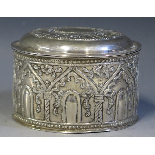 704 - A Persian circular silver box and cover, stamped marks, with embossed arcaded decoration on a circul... 