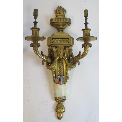 1316 - A pair of Empire style gilt brass twin branch wall lights, surmounted with flaming urns on a taperin... 