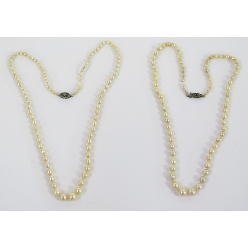 107 - Two Pearl or Cultured Pearl Necklaces, both with precious white metal clasps, one set with diamonds ... 