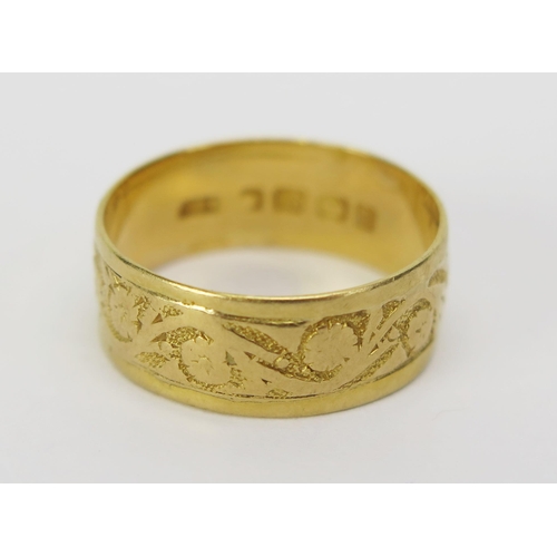 23 - A Victorian 18ct Gold Wedding Band decorated with chased foliate scroll work, 7.3mm wide, size O.5, ... 