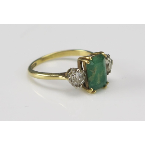 249 - An 18ct Gold, Emerald and Diamond Platinum Set Ring, c. 9x6.3mm principal stone flanked by old cuts,... 