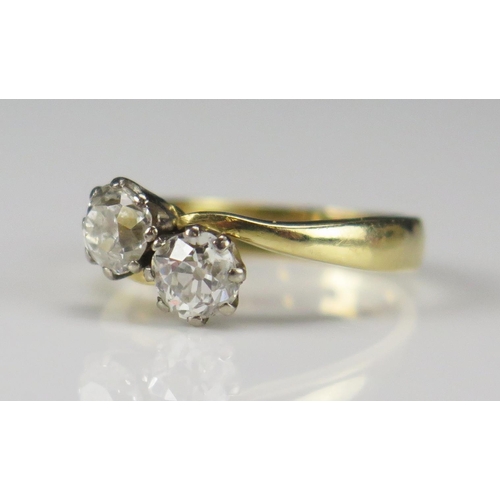 59 - An 18ct Gold and Old Cut Diamond Two Stone Crossover Ring, size H.25, hallmarked c. 4.6-5mm stones, ... 
