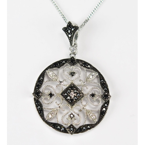 81 - A Round Silver Pendant set with black and white cubic zirconia on a silver chain