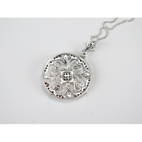 81 - A Round Silver Pendant set with black and white cubic zirconia on a silver chain